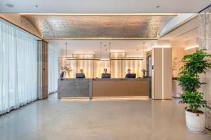 an office lobby with a reception desk and two people at Atour Hotel Quanzhou Hongchang Baozhou Road in Quanzhou