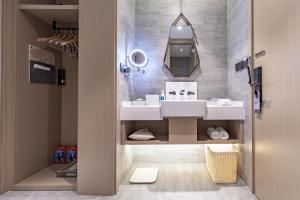 a bathroom with a sink and a mirror at Atour Hotel Yichun Administrative Center in Yichun