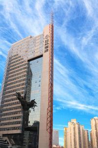 ein hohes Gebäude mit einer Vogelstatue davor in der Unterkunft Atour Hotel Shenzhen Nanshan Coast City in Shenzhen