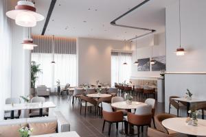 un ristorante con tavoli, sedie e finestre di Atour S Hotel Ningbo Zhousu Yejiang a Ningbo