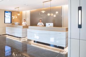 two people sitting at a counter in a restaurant at Atour Hotel Zhuhai High Tech Zone University Town Government Affairs Center in Zhuhai