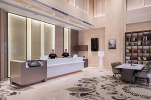 two men sitting at a reception desk in a hotel lobby at Atour X Hotel Guangzhou Baiyun International Airport Renhe Station in Guangzhou