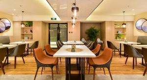 a restaurant with tables and chairs in a room at Atour Hotel Shenyang Youth Street Golden Gallery in Shenyang
