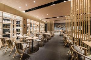 a restaurant with tables and chairs and wine bottles at Atour Hotel Shanghai World Expo Center in Shanghai