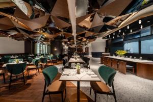un restaurante con mesas y sillas y un techo con triángulos en A T HOUSE Shanghai Xujiahui, en Shanghái