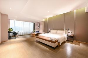 a bedroom with a large bed and a desk and a table at Atour Hotel Beijing Yizhuang New Town Majuqiao in Daxing
