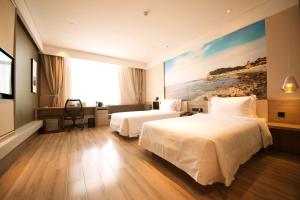 Atour Hotel Yantai South Station Yingchun Street في يانتاى: غرفة فندقية بسريرين ولوحة على الحائط