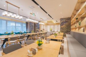 Atour Hotel Shanghai Wujiaochang Dabaishu في شانغهاي: مطعم بطاولات وكراسي خشبية