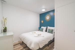 a bedroom with a white bed and a blue wall at Pauline's Home Gambetta - Proche Cathédrale - Calme in Reims