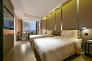 a hotel room with two beds and a table at Atour Hotel Dongguan Nancheng International Trade Center in Dongguan