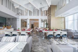 a restaurant with couches and tables and chairs at Atour Hotel Hefei North Square South Station in Hefei