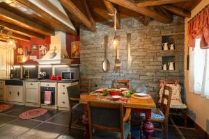 una cucina con tavolo e parete in pietra di Mystiko Art House by Eutopia 