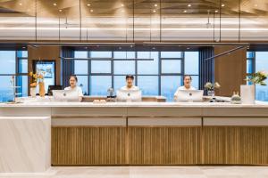 a group of people sitting at a desk with laptops at Atour Hotel Wuxi Coast City in Wuxi