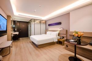 Habitación de hotel con cama blanca y TV en Atour X Hotel Chaozhou Xiangqiao International Financial Business Center, en Chaozhou
