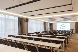 泰安泰安泰山景区盘古天地亚朵酒店的一个带桌椅和标志的空讲堂