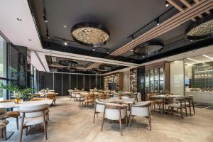 a restaurant with tables and chairs and windows at Atour Hotel Shanghai Wujiaochang West Yingao Road Station in Shanghai