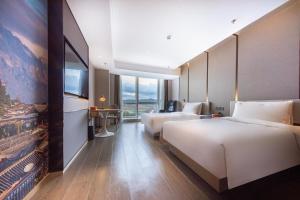Cette chambre comprend 2 lits et une télévision à écran plat. dans l'établissement Atour Hotel Kunming Municipal Government Chunrong Street, à Kunming