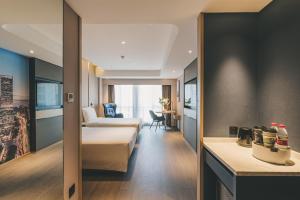 a hotel room with a bed and a desk at Atour S Hotel Shanghai Xujiahui Tianyaoqiao in Shanghai
