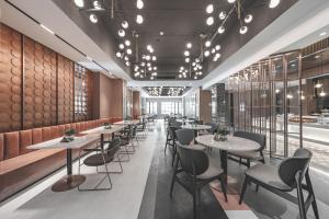 a row of tables and chairs in a restaurant at Atour Light Hotel Hangzhou Xiasha in Hangzhou