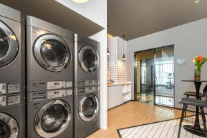 a laundry room with four washer and dryer machines at Atour Hotel Xiamen Meifeng Binhai Romantic Line in Tong'an