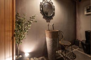 bagno con vasca, specchio e sedia di Mystiko Art House by Eutopia 