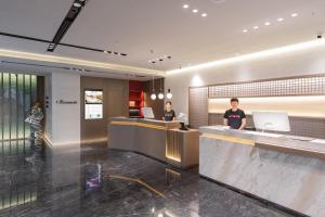 a lobby of a hotel with two people at a counter at Atour Hotel Beijing Guomao Tuanjie Lake in Beijing