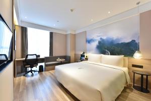 una camera d'albergo con un letto grande e una scrivania di Atour Hotel Beijing Yizhuang Mobile Silicon Valley a Daxing Altre 30 foto