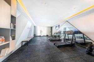 a gym with a row of treadmills and benches at Atour Hotel Hefei Pearl Plaza Huijin Business Center in Hefei