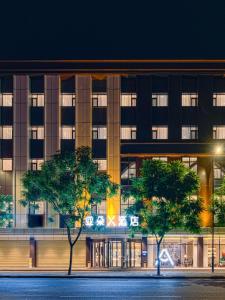 a building with trees in front of it at night at Atour X Hotel Chengdu Shuangnan Wuhou Avenue Station in Chengdu