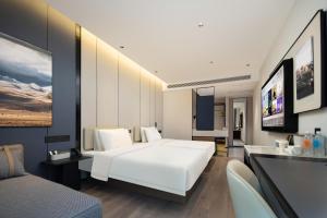 a bedroom with a large white bed and a living room at Atour Hotel Nantong North Street Vientiane City in Nantong +20 photos