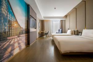 a hotel room with two beds and a painting on the wall at Atour Hotel Shenzhen Nanshan Shekou in Shenzhen