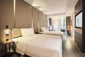 a hotel room with two beds and a television at Atour Hotel Chongqing Tiandi NetEase Cloud Music in Chongqing