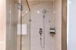 a shower in a bathroom with a glass door at Atour Hotel Xiamen Xiagu Cruise Center in Xiamen +43 photos