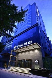 a large blue building with stairs in front of it at Atour Hotel Dalian Zhongshan Square in Dalian