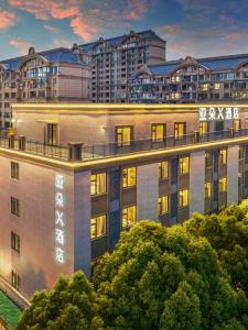 ein Apartmenthaus mit Licht in einer Stadt in der Unterkunft Atour X Hotel Shanghai Jinshan Wanda Plaza City Beach in Jinshan