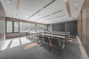 a conference room with tables and chairs and windows at Atour Light Hotel Hangzhou Xiasha in Hangzhou
