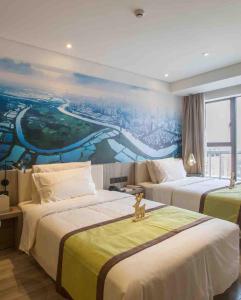 a hotel room with two beds with a painting on the wall at Atour Hotel Shenzhen Nanshan Coast City in Shenzhen