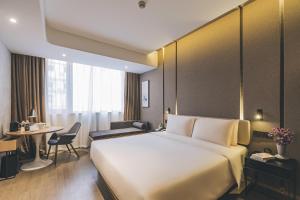 a hotel room with a large bed and a table at Atour Hotel Shanghai The Bund East Nanjing Road-Self-service free laundry in Shanghai