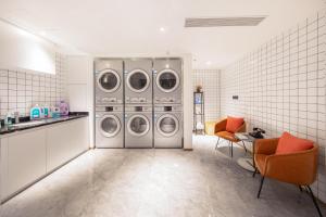 a laundry room with four washing machines in it at Atour Hotel Zhuhai Wanchai Port Hengqin International Convention and Exhibition Center in Zhuhai