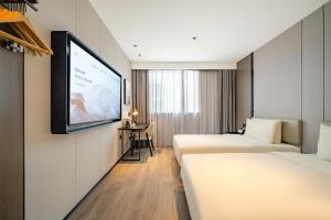 a hotel room with two beds and a flat screen tv at Atour X Hotel Shanghai Central Bailian Tongchuan Road Station in Shanghai