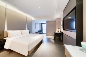 杭州的住宿－杭州滨江宝龙城亚朵酒店，卧室配有一张白色大床和一张书桌