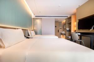 een groot wit bed in een hotelkamer bij Atour Light Hotel Shenzhen Nanshan Shenzhen Bay in Shenzhen
