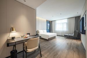 a hotel room with a bed and a desk and a bedroom at Atour Hotel Shanghai Huajing in Shanghai