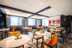 a restaurant with tables and chairs and a bar at Atour X Hotel Chaozhou Xiangqiao International Financial Business Center in Chaozhou