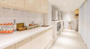 a kitchen with white cabinets and a washer and dryer at Atour Hotel Hangzhou West Lake Cultural Plaza Shangtang Road in Hangzhou