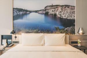 a bedroom with a bed with a view of a lake at Atour Hotel Shanghai Minhang Industrial Park in Shanghai