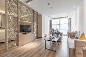 a living room with a couch and a tv at Atour Hotel Xiamen Xiagu Cruise Center in Xiamen
