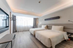 Ένα ή περισσότερα κρεβάτια σε δωμάτιο στο Atour Light Hotel Shanghai Xujiahui Jiaotong University