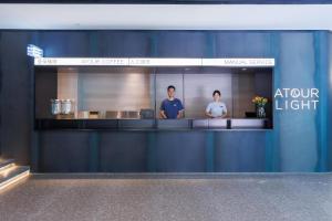 a store front with a counter with two people in it at Atour Light Hotel Kunming Dianchi Road South Asia Style First City in Kunming