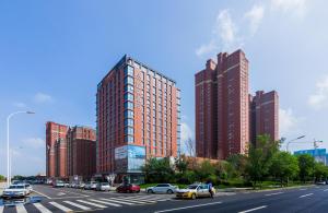 瀋陽市にあるAtour Hotel Shenyang South Station Quanyun Roadの車や高層ビルが並ぶ賑やかな街道